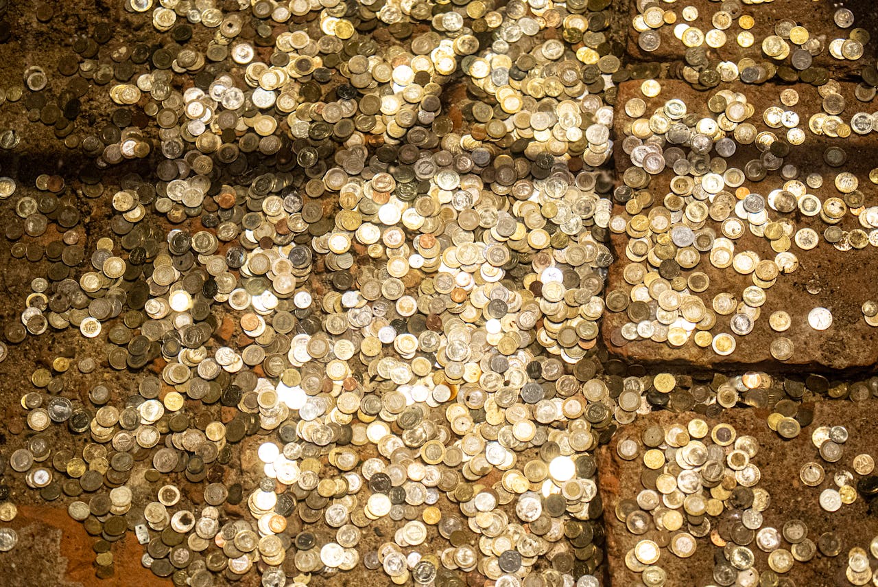 Scattered coins reflecting light in the historic Basilica Cistern of Istanbul.